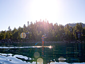Woman Paddling on Lake with Sun Flares, Looking Down