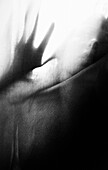 Blurred Distorted Hand and Face Against Sheer Fabric