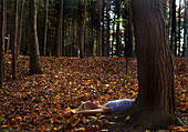 Woman Laying on Ground at Base of Tree