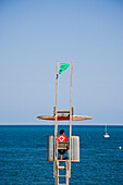 Lifeguard on beach tower, Barcelona, Spain