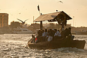 People on water taxi at dusk at the Creek, Dubai, UAE