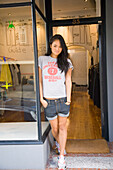 Australia, Sydney, William Street, Paddington, Young woman standing in shop door