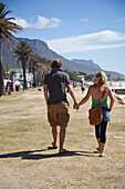 South Africa, Cape Town, Couple walking down sea promenade, Camps Bay