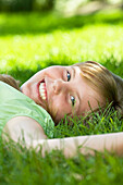 Portrait Of Young Girl Laying In Grass