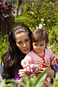 Mother And Child Looking At Flowers Outside In A Garden, Vancouver British Columbia