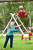 Grandmother and grandson (7 years) on a playground, Styria, Austria