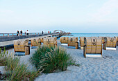 Baltic sea beach with hooded beach chairs and pier, Kellenhusen, Schleswig-Holstein, Germany