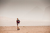 Woman hiking through desert scenery, Wadi Rum, Jordan, Middle East