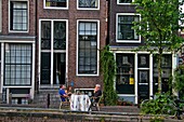 People sitting at outdoors oh theirs house, Amsterdam, Holland