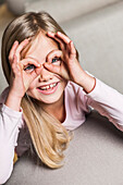 Girl circling eyes with fingers, Hamburg, Germany