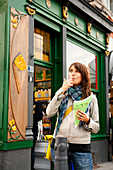 Woman eating chips in front of a takeway, Liege, Wallonia, Belgium
