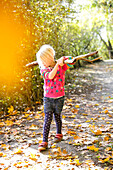 Mädchen (4 Jahre) spielt im Herbstwald, Goseck, Sachsen-Anhalt, Deutschland