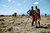 Two young men from the Massai tribe in the savanne in front of Kilimandjaro, Kenya, Africa
