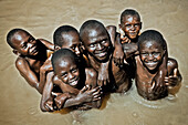 Children bathing in a water hole, Kenya, Africa