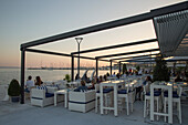 Menschen sitze draußen in einer Bar an der Uferpromenade, Split, Dalmatien, Kroatien, Europa
