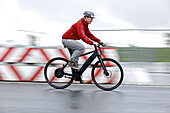 Woman riding an electric bicycle on a test track, Tanna, Thuringia, Germany