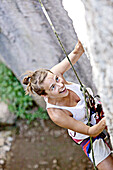 Frau klettert eine Felswand hinauf, Finale Ligure, Provinz Savona, Ligurien, Italien