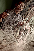 Fisherman reparing fishnet, Mataram, Lombok, Indonesia