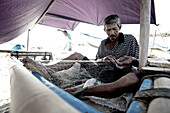 Fischer repariert Fischernetz, Mataram, Lombok, Indonesien