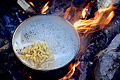 Cooking pasta above a campfire, long-distance footpath Lycian Way, Antalya, Turkey