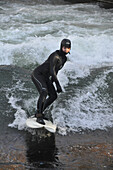 River surfer in the English Garden park, winter in Munich, Bavaria, Germany