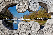 Blick durch das Brückengeländer der Ludwig-Ferdinand-Brücke über den Schlosskanal mit Blick auf Schloss Nymphenburg, München, Oberbayern, Bayern, Deutschland