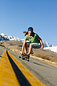 Young woman skateboarding in Bishop, California with mountains in the background Bishop, California, USA