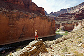A young woman takes in the view above the Colorado River at the Grand Canyon in Arizona Arizona, USA