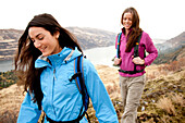 Two females  in bright clothes hiking in the Columbia River Gorge, Oregon Hood River, Oregon, USA