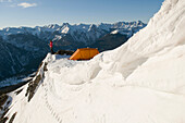 A woman camping on a snowy ridge above Molas Pass, San Juan National Forest, Colorado Silverton, Colorado, USA