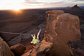 A woman completing the tyrolean traverse between the two sandstone summits, Indian Creek, Monticello, Utah Monticello, Utah, USA