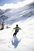 A woman skis in Utah under bright, blue skies Salt Lake City, Utah, USA