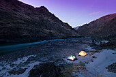 Tents glow at twilight while camping in the canyon Whitebird, Idaho, USA