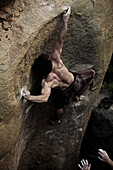 A muscular climber reaches into a difficult move in Hampi, India Hampi, Karnataka, India