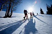 Low angle silhouette of four men backcountry ski touring Wendover, Nevada, USA