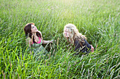 Girls sit in a grassy field in Sandpoint, Idaho Sandpoint, Idaho, USA