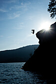 A young man flips off a rock outcropping in Idaho Sandpoint, Idaho, USA
