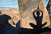 A shadow on a boulder of a woman practicing yoga Lone Pine, California, USA