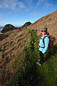 A woman hikes near a beach on the Oregon Coast Port Orford, Oregon, USA