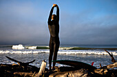 A teenage male stretches before he goes surfing in Ventura, California Ventura, California, United States of America