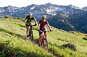 A couple enjoys a spring ride on the Wastach Crest trail Utah, USA