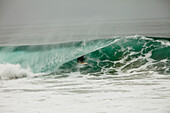 A male surfer navigates the barrel while surfing at Westward in Malibu, California Malibu, California, United States of America