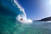 A water view of a surfer girl in the tube, in Hawaii north shore of Oahu, Hawaii, USA