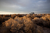 An SUV rests amid sagebrush in Utah's desert Utah, USA