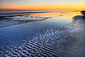 A sunset is reflected at low tide at Coligny Beach on Hilton Head Island, South Carolina Hilton Head Island, South Carolina, USA