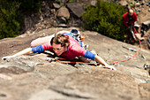 An adult female climber shows her game-face on a route in Australia Hobart, Tasmania, Australia