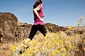 An athletic woman jogging in the Columbia Gorge, Oregon Hood River, Oregon, USA