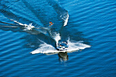 A athletic wakeboarder jumps the wake going huge on a calm day in Idaho Sandpoint, Idaho, USA