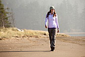 Female enjoying a hike along the beach Pacific City, Oregon, USA