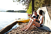 Two young adults laugh and smile on a camping and kayaking trip in Idaho Sandpoint, Idaho, USA